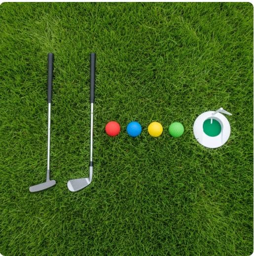 Starter golf equipment for a toddler: a short putter, a small club, foam balls, and a practice cup